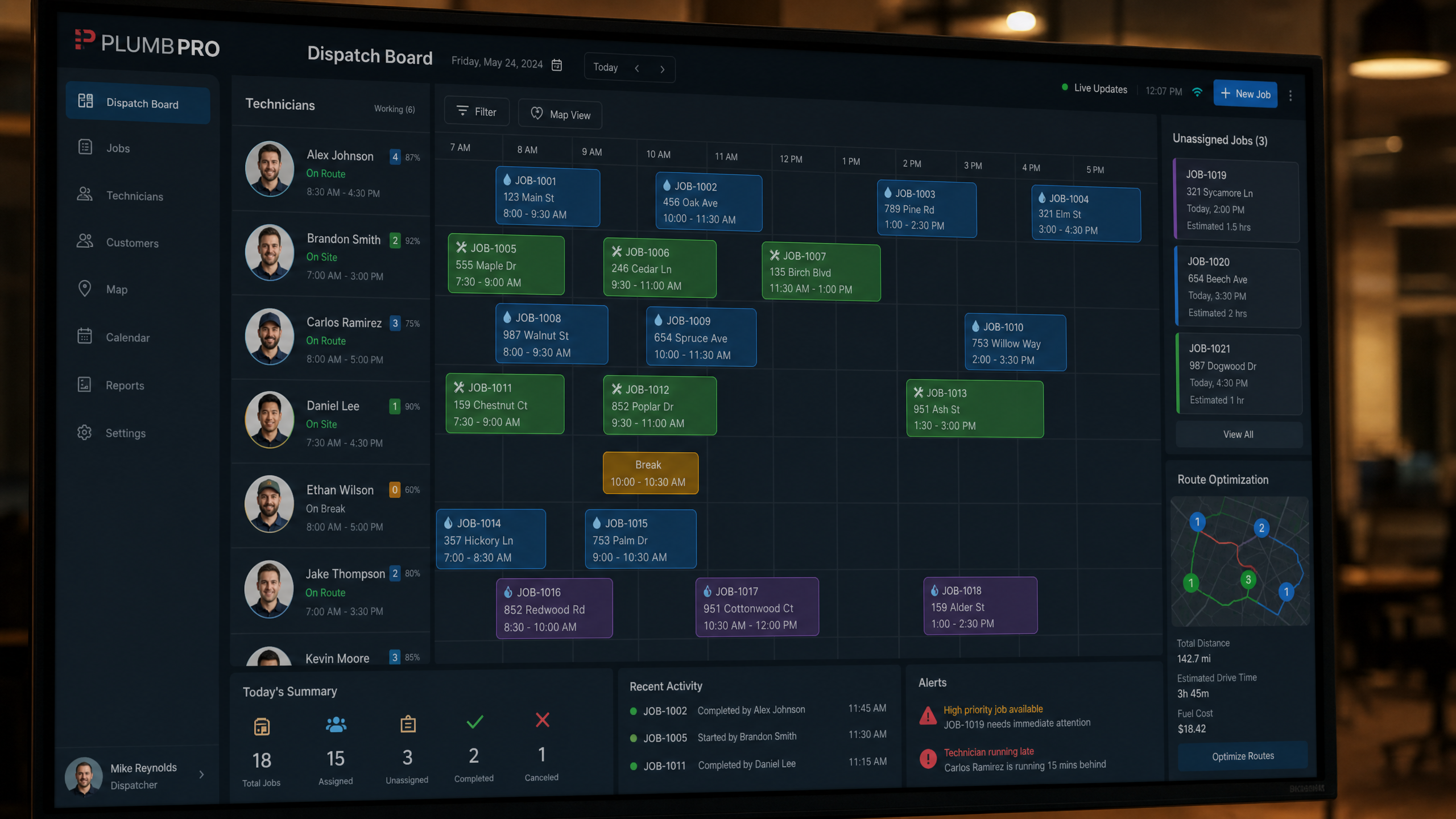 Large digital dispatch board on a monitor showing plumbing technician schedules, job assignments, and route optimization